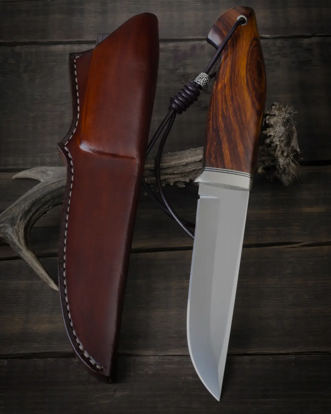 Jaktkniv med trähandtag och slida liggande på träbord efter slipning | Säffle Slipservice